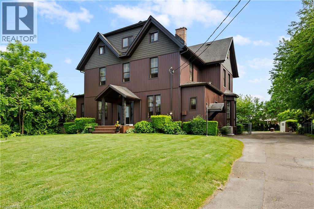View of front of home with a chimney, a front lawn, and asphalt driveway - 5368 Menzie Street, Niagara Falls, ON - Outdoor With Facade