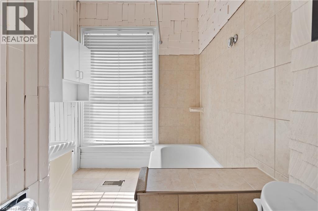 Full bathroom featuring toilet and tile patterned flooring - 5368 Menzie Street, Niagara Falls, ON - Indoor Photo Showing Bathroom