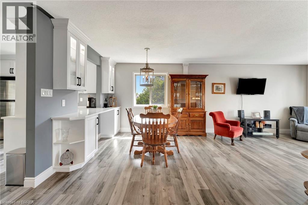 Dining room with light wood-style flooring, a textured ceiling, and a chandelier - 1565 Old Brock Street, Vittoria, ON - Indoor