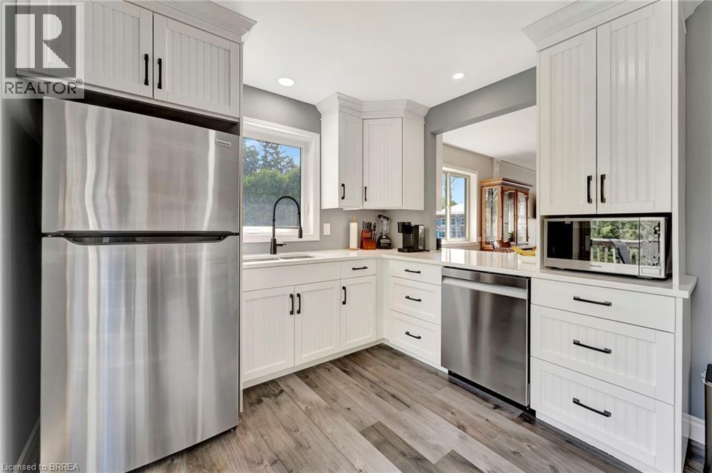 Kitchen with appliances with stainless steel finishes, light wood-type flooring, healthy amount of natural light, white cabinetry, and recessed lighting - 1565 Old Brock Street, Vittoria, ON - Indoor Photo Showing Kitchen