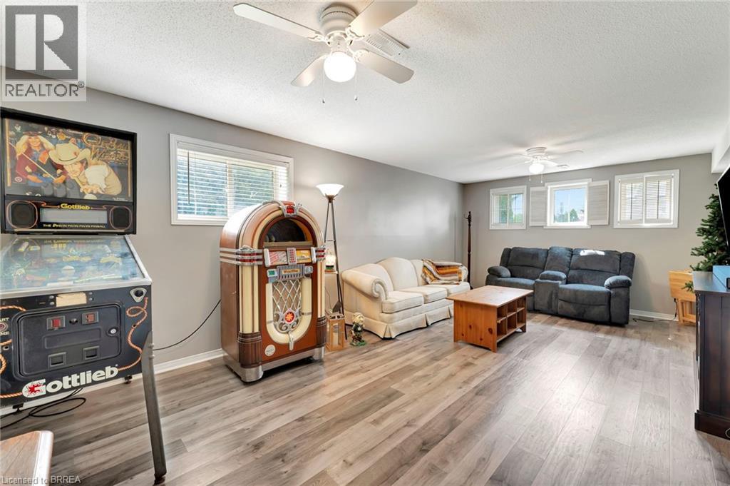 Living room with plenty of natural light, light wood-style floors, a textured ceiling, and ceiling fan - 1565 Old Brock Street, Vittoria, ON - Indoor