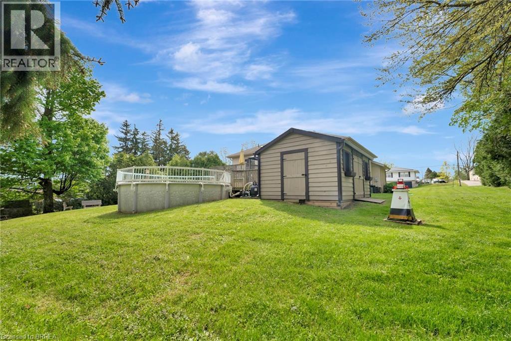 View of grassy yard with a storage shed - 1565 Old Brock Street, Vittoria, ON - Outdoor With Above Ground Pool