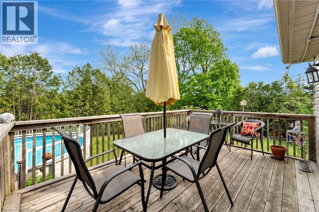 Deck with outdoor dining space and view of wooded area - 1565 Old Brock Street, Vittoria, ON - Outdoor With Deck Patio Veranda With Exterior
