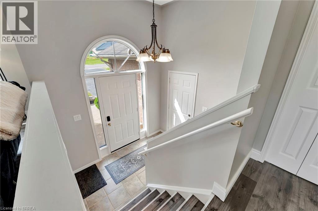 Foyer entrance featuring a chandelier, stairs, and a towering ceiling - 1565 Old Brock Street, Vittoria, ON - Indoor Photo Showing Other Room