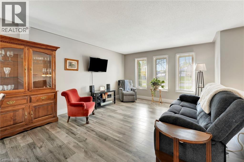 Living room featuring light wood-type flooring and a textured ceiling - 1565 Old Brock Street, Vittoria, ON - Indoor Photo Showing Living Room
