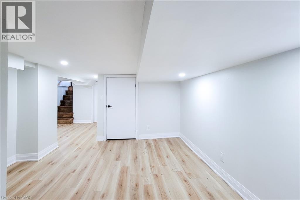 Finished below grade area with light wood-style floors, stairway, and recessed lighting - 51 West Avenue N, Hamilton, ON - Indoor Photo Showing Other Room