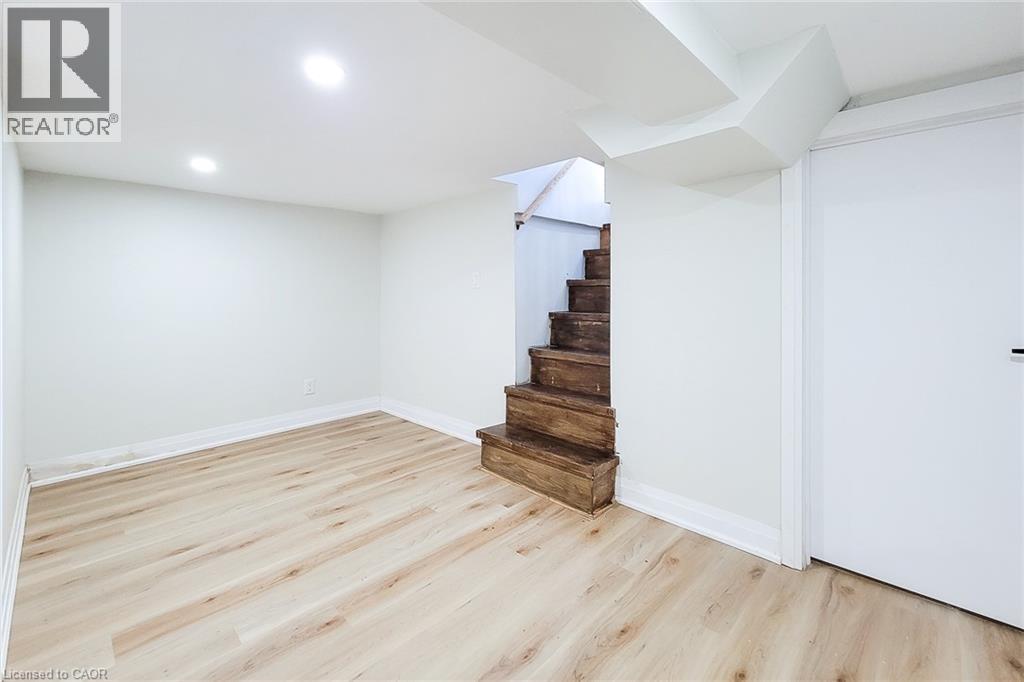 Finished basement with light wood-style floors, recessed lighting, and stairway - 51 West Avenue N, Hamilton, ON - Indoor Photo Showing Other Room