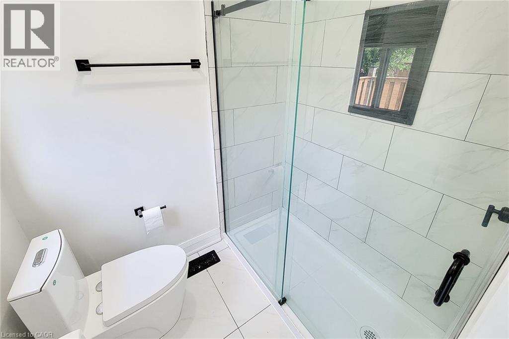 Full bath featuring a stall shower and tile patterned flooring - 51 West Avenue N, Hamilton, ON - Indoor Photo Showing Bathroom