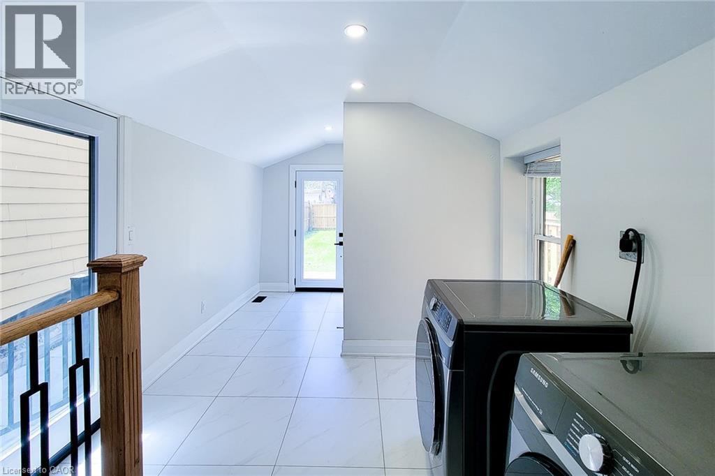 Laundry room with vaulted ceiling, recessed lighting, and washer and clothes dryer - 51 West Avenue N, Hamilton, ON - Indoor Photo Showing Laundry Room