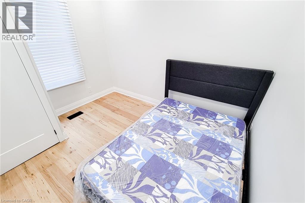 Bedroom with light wood-style floors and baseboards - 51 West Avenue N, Hamilton, ON - Indoor Photo Showing Bedroom