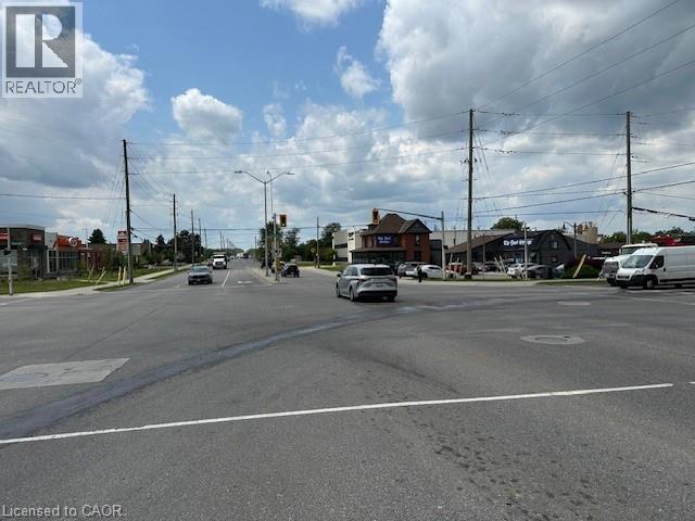 View of asphalt road with street lights, sidewalks, and curbs - 1360 E Rymal Road E, Hamilton, ON