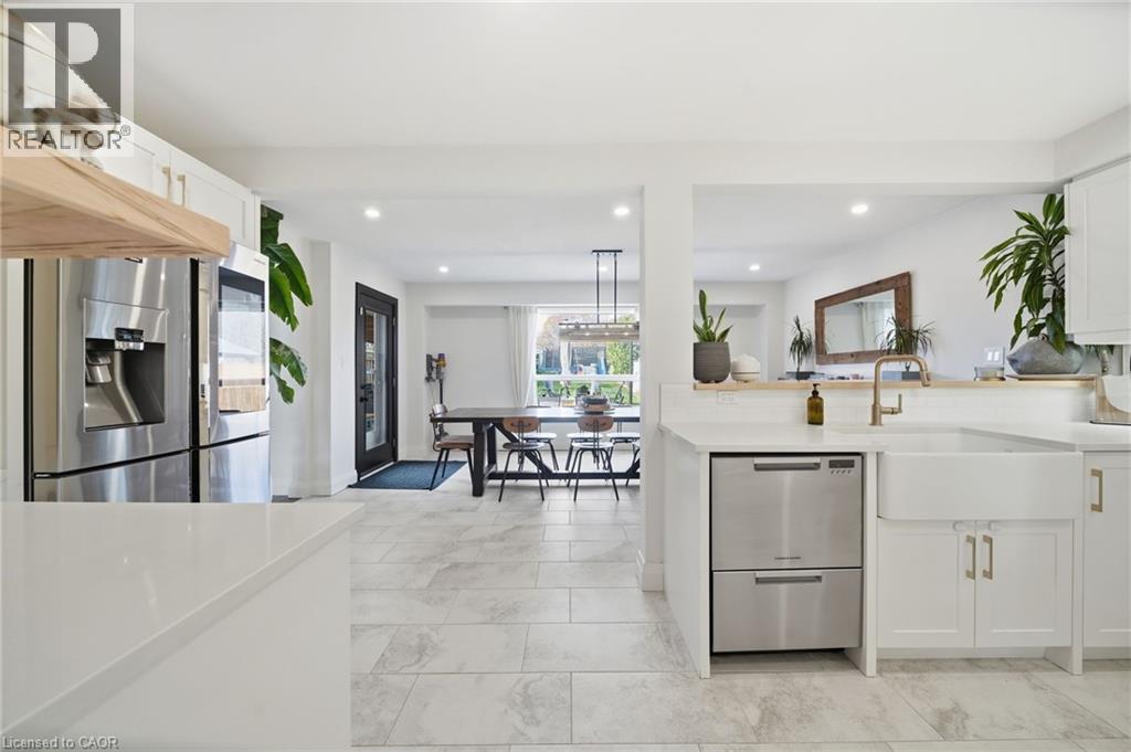Kitchen featuring white cabinets, stainless steel appliances, light stone countertops, and recessed lighting - 136 Braemar Avenue, Caledonia, ON - Indoor Photo Showing Other Room