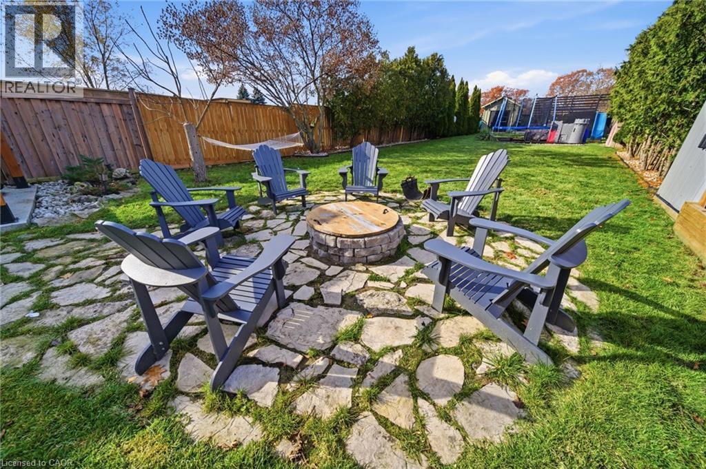 Fenced backyard with a trampoline, an outdoor fire pit, and a patio - 136 Braemar Avenue, Caledonia, ON - Outdoor With Backyard