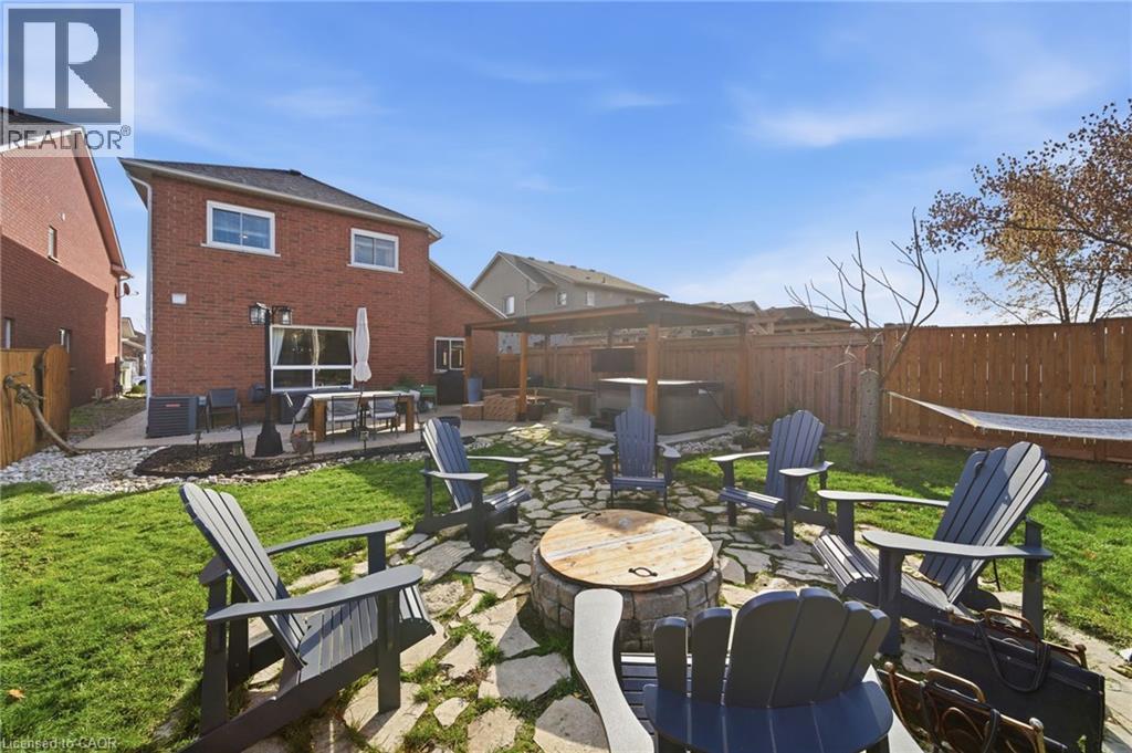 Fenced backyard featuring a patio, an outdoor fire pit, and a hot tub - 136 Braemar Avenue, Caledonia, ON - Outdoor