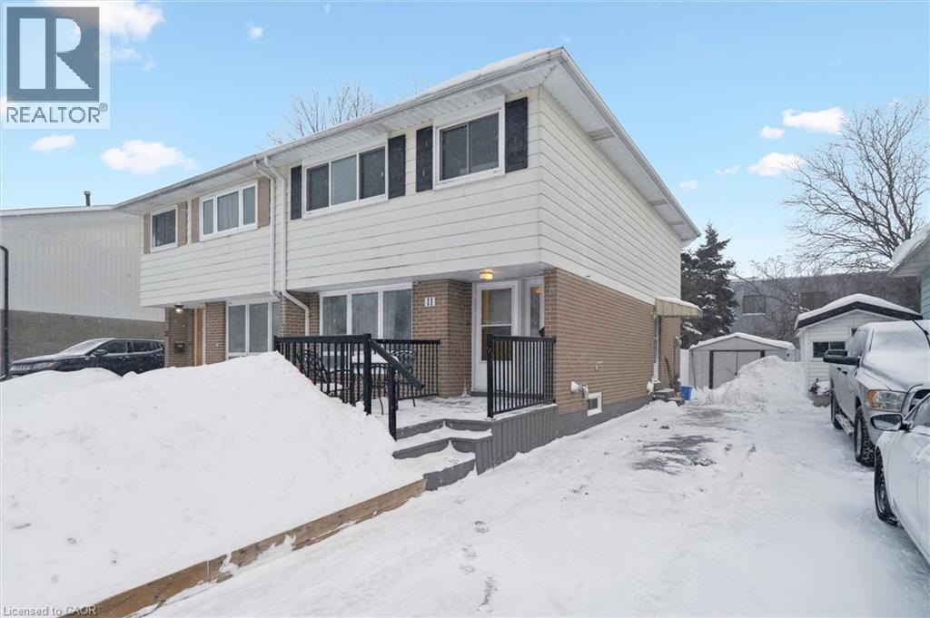 View of front facade featuring brick siding, a deck, and an outdoor structure - 11 Ingleside Drive, Kitchener, ON - Outdoor With Deck Patio Veranda