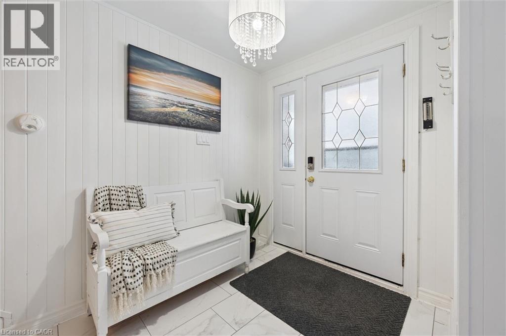 Foyer featuring wooden walls, a chandelier, light marble finish floors, and crown molding - 11 Ingleside Drive, Kitchener, ON - Indoor Photo Showing Other Room