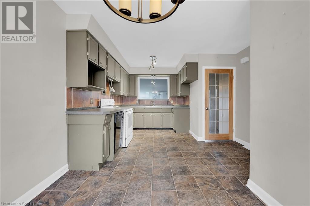 Kitchen featuring gray cabinetry, range, and baseboards - 9 Gavin Drive, St. Catharines, ON - Indoor Photo Showing Kitchen