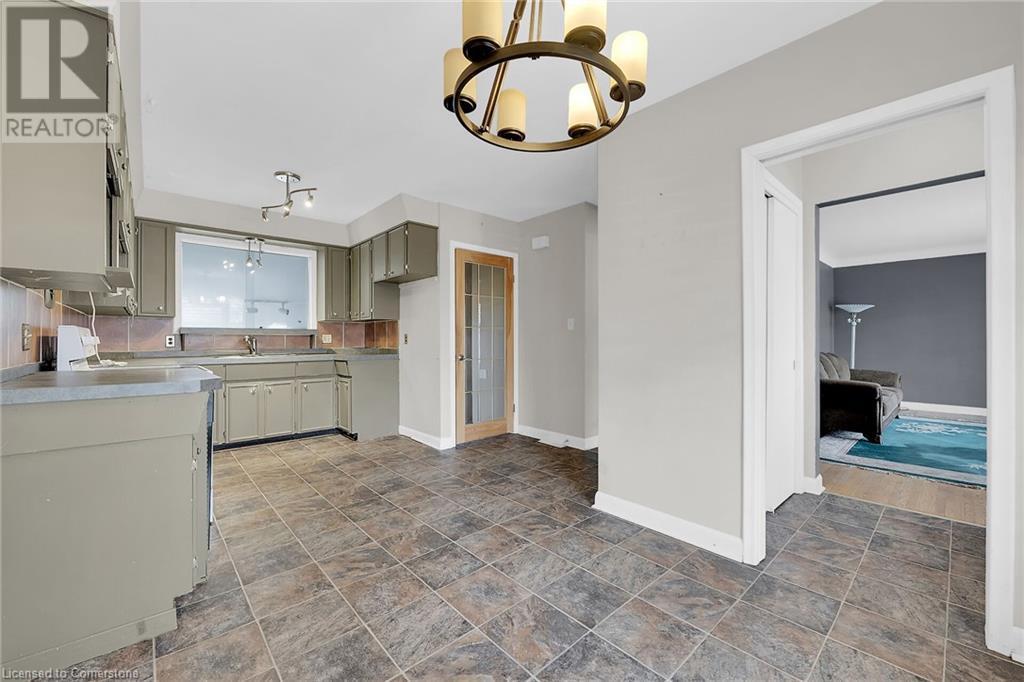 Kitchen featuring range, a notable chandelier, light countertops, and baseboards - 9 Gavin Drive, St. Catharines, ON - Indoor Photo Showing Kitchen