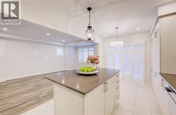 Kitchen featuring decorative light fixtures, white cabinetry, a kitchen island, recessed lighting, and light tile patterned flooring -