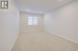 Empty room with light carpet and recessed lighting -