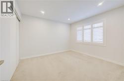 Empty room with light carpet and recessed lighting -