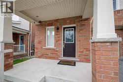 Property entrance featuring covered porch and brick siding -