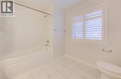 Bathroom with tile patterned flooring and shower combination -