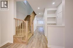 Corridor with light wood-type flooring, recessed lighting, and stairs -