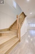 Stairway featuring wood finished floors and recessed lighting -