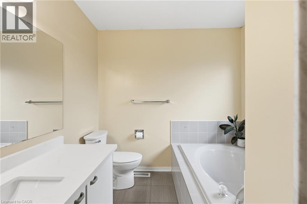 Full bath featuring a bath, vanity, and dark tile patterned flooring - 3372 Bobwhite Mews, Mississauga, ON