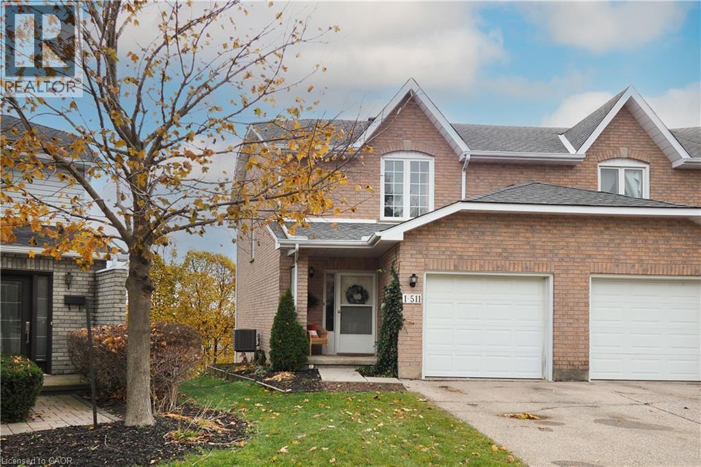 View of front of home featuring brick siding, shingled roof, front lawn, and single car garage - 511 Oakvale Drive Unit# 1, Waterloo, ON - Outdoor With Facade