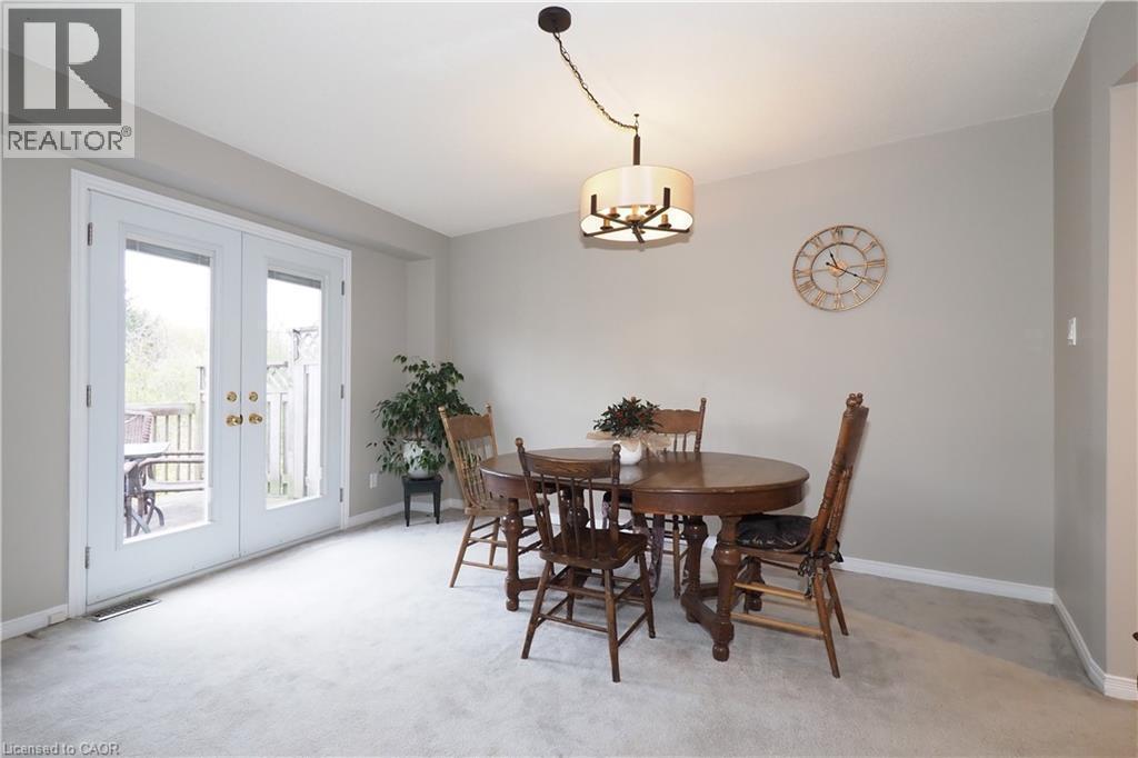 Dining room with swagged chandelier and French doors leading to outdoor wooden deck - 511 Oakvale Drive Unit# 1, Waterloo, ON - Indoor Photo Showing Dining Room