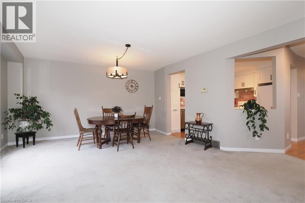 Dining room with light carpet and swagged chandelier - 511 Oakvale Drive Unit# 1, Waterloo, ON - Indoor