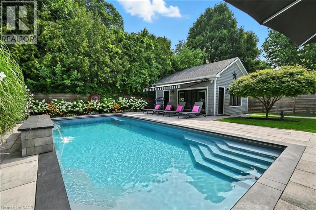 View of pool with a fenced backyard, a patio, an outdoor structure, and view of wooded area - 735 George Street, Burlington, ON - Outdoor With In Ground Pool