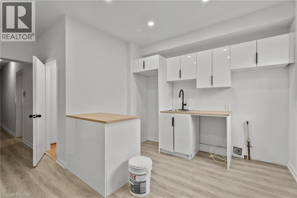 Kitchen featuring white cabinets, modern cabinets, light wood-style flooring, recessed lighting, and butcher block countertops - 246 Mary Street, Hamilton, ON