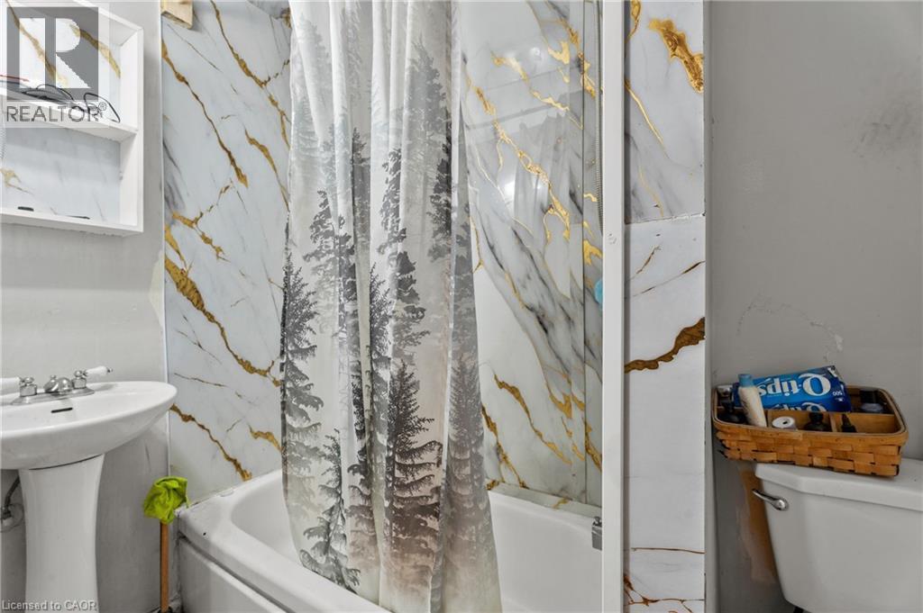 Bathroom featuring toilet and a combined bath / shower with marble appearance - 246 Mary Street, Hamilton, ON