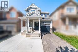 View of front of home featuring covered porch, driveway, an attached garage, and stone siding -