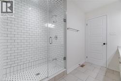 Full bath with vanity, light tile patterned floors, and a stall shower -