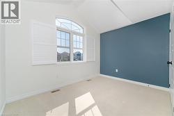 Carpeted empty room with lofted ceiling and baseboards -