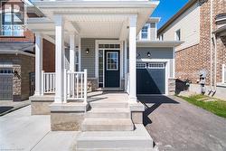 Property entrance featuring a porch, asphalt driveway, and stone siding -