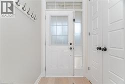 Doorway to outside with wood finished floors and baseboards -