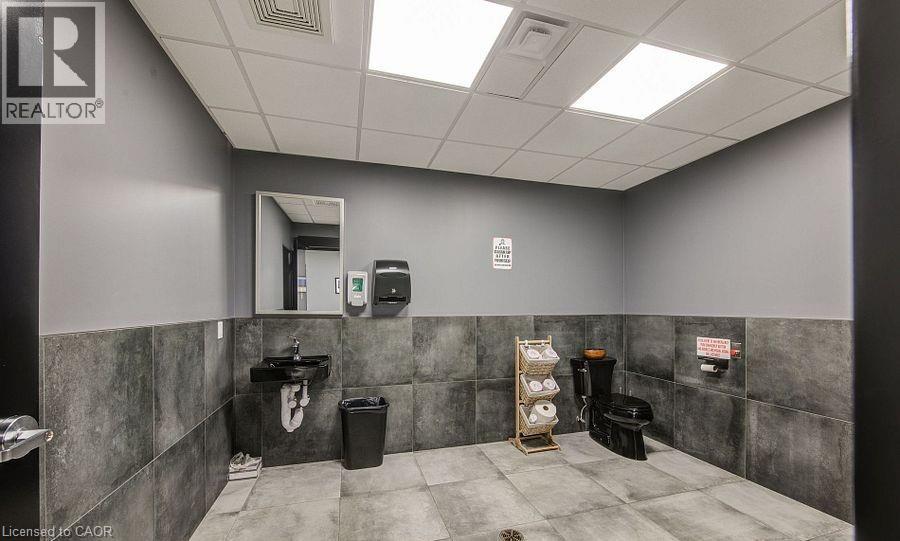Bathroom with tile walls, a paneled ceiling, and wainscoting - 55 Progress Drive E, Aylmer, ON