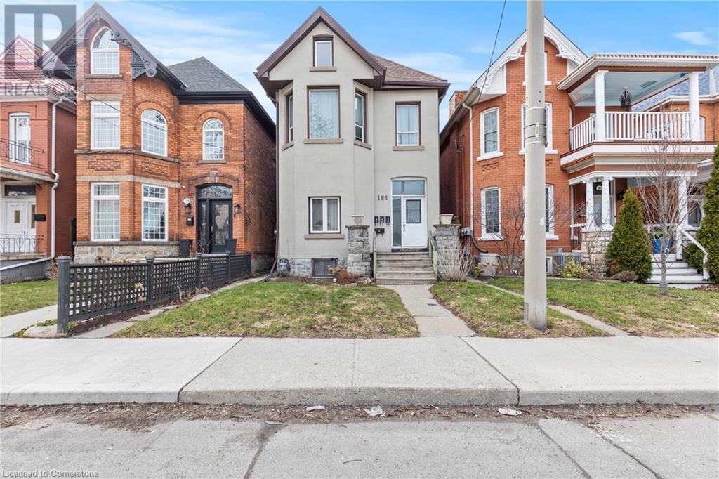 Townhome / multi-family property featuring stucco siding and a front lawn - 181 West Avenue N, Hamilton, ON - Outdoor With Facade