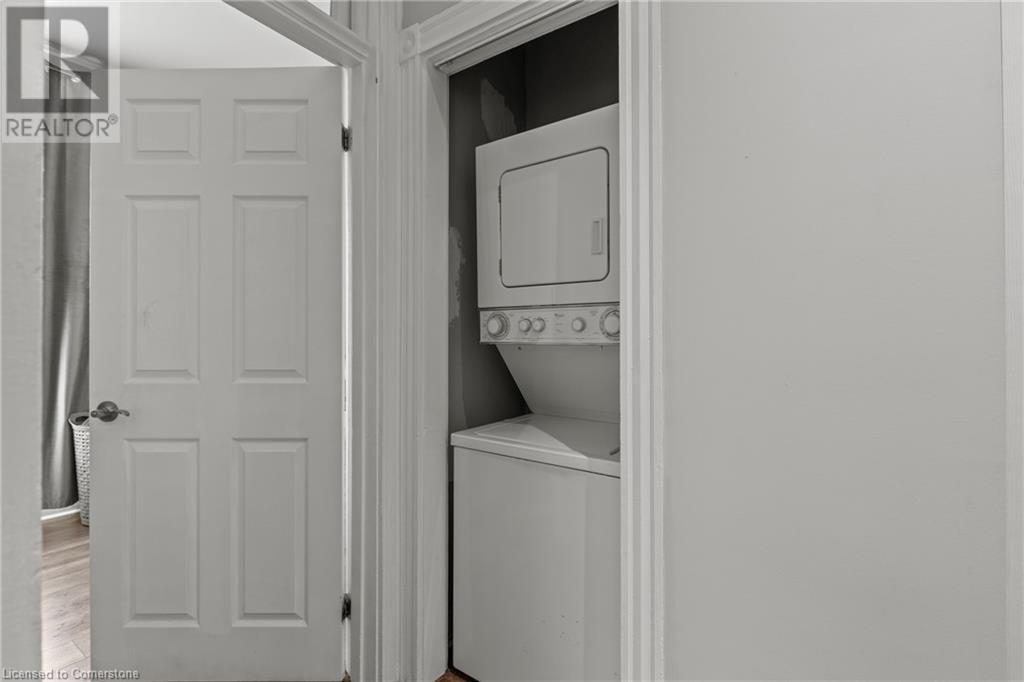 Clothes washing area with stacked washer and clothes dryer and laundry area - 181 West Avenue N, Hamilton, ON - Indoor Photo Showing Laundry Room