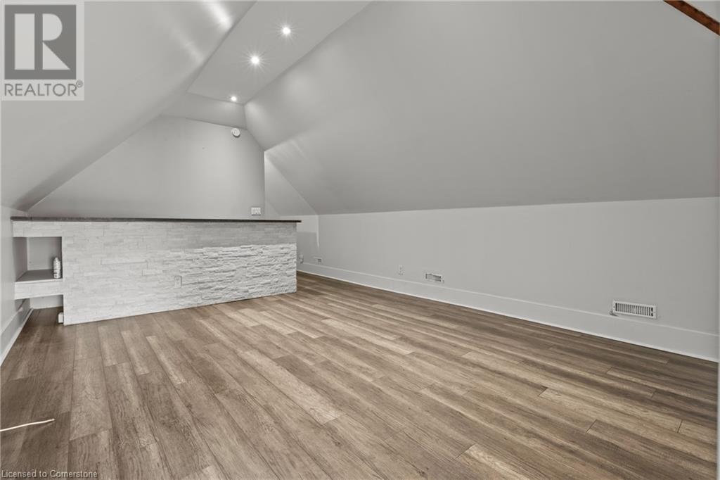 Bonus room featuring wood finished floors, baseboards, vaulted ceiling, and visible vents - 181 West Avenue N, Hamilton, ON - Indoor Photo Showing Other Room
