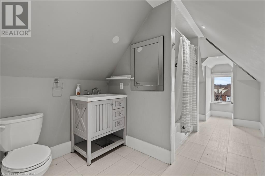 Full bathroom with baseboards, toilet, vanity, a shower with curtain, and lofted ceiling - 181 West Avenue N, Hamilton, ON - Indoor Photo Showing Bathroom