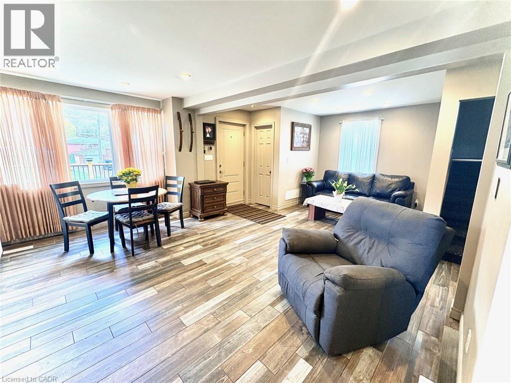 Open-concept living area featuring wood-finish flooring, recessed lighting, and ample natural light from multiple windows - 199 Kimberly Drive, Hamilton, ON - Indoor
