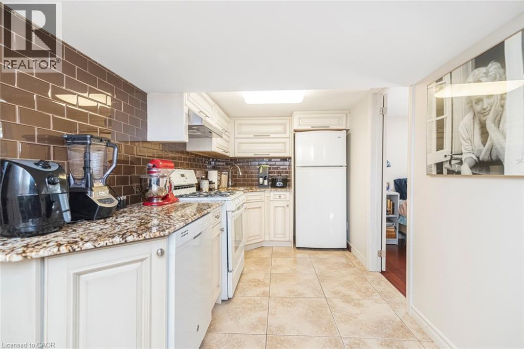 Lower level kitchen with glass back splash and ceramic tile flooring - 199 Kimberly Drive, Hamilton, ON - Indoor Photo Showing Kitchen