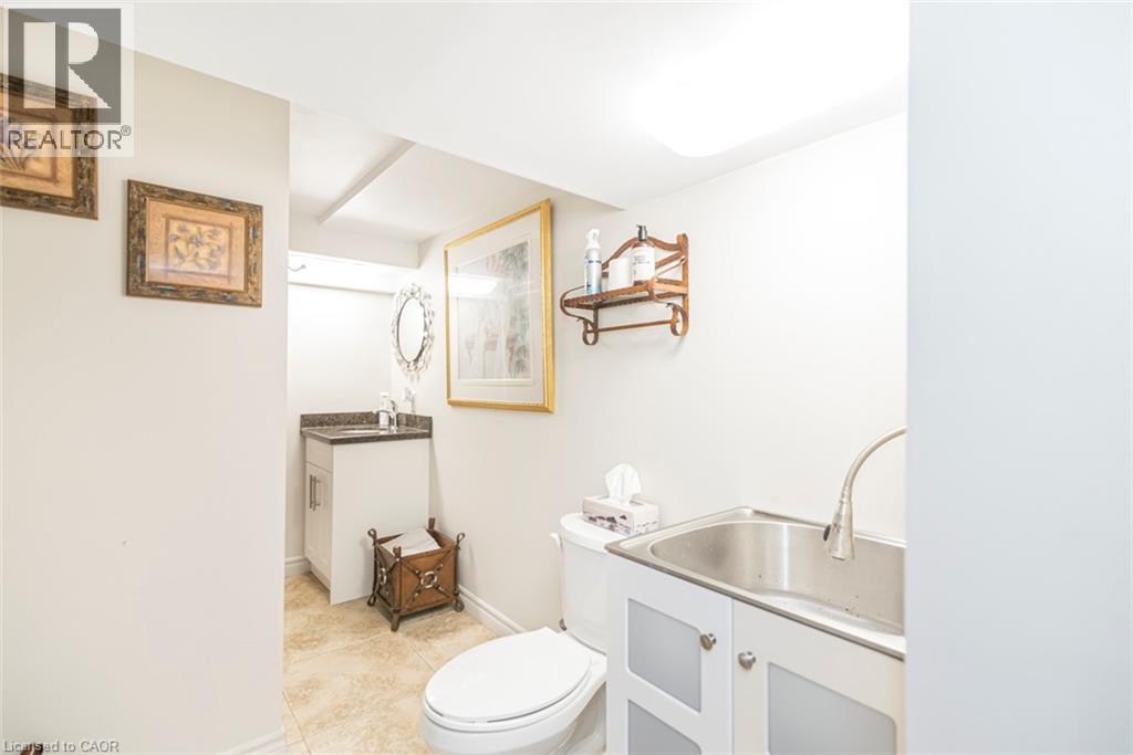 Lower level four piece bathroom with washer dryer and wash basin - 199 Kimberly Drive, Hamilton, ON - Indoor Photo Showing Bathroom