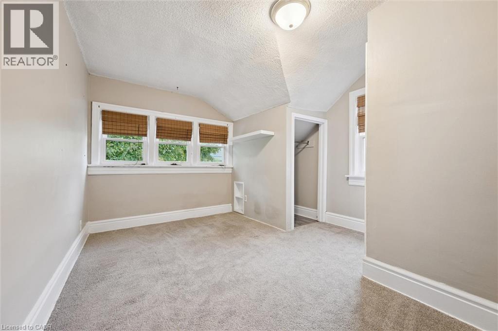 Unfurnished room with a textured ceiling, vaulted ceiling, and light colored carpet - 41 Rose Street, Kitchener, ON - Indoor Photo Showing Other Room